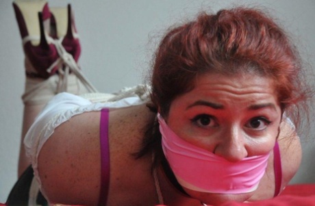 Redheaded woman is hogtied with her clothes on and gagged as well 29213871