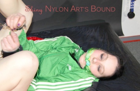 White girl is left attached to a spreader bar in nylon shorts and a raincoat 72311390