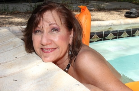 Horny mature woman dildos fucks her pussy while on an inflatable in the pool 47617463