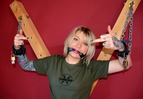 Inked blonde Roxxxi Manson struggles while restrained to a St Andrew's Cross 67393841